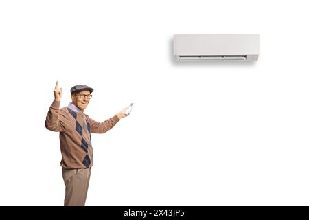 Elderly man putting on AC unit and pointing up isolated on white background Stock Photo