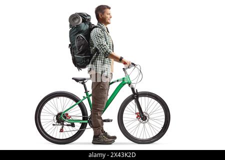 Full length profile shot of a man with a backpack standing with a bicycle isolated on white background Stock Photo