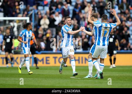 Huddersfield Town's Rhys Healey celebrates with teammates after scoring their side's first goal during the Sky Bet Championship match at John Smith's Stadium, Huddersfield. Picture date: Saturday April 27, 2024. Stock Photo