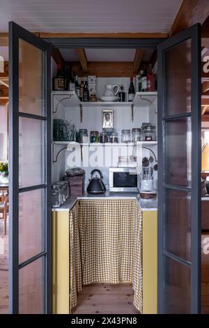 View through oipen double doors to pantry in East Sussex home, South East England, UK Stock Photo
