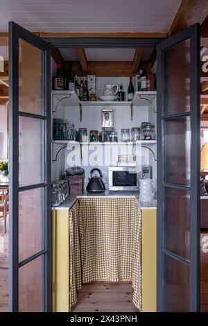 View through oipen double doors to pantry in East Sussex home, South East England, UK Stock Photo