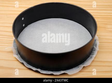 Round baking pan with removable bottom and baking paper. Stock Photo