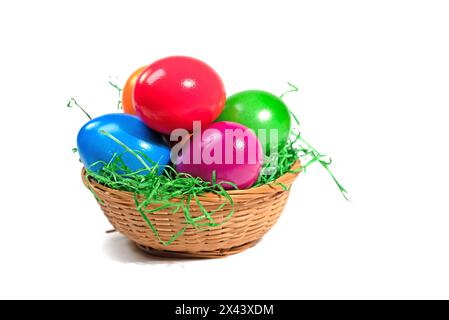 Colorful Easter eggs in a basket against a white background Stock Photo
