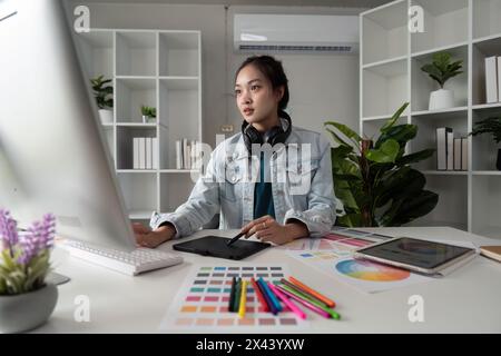 Graphic or UI designer work on computer laptop and with tablet after brainstorming unique design with professional developer UX team Stock Photo