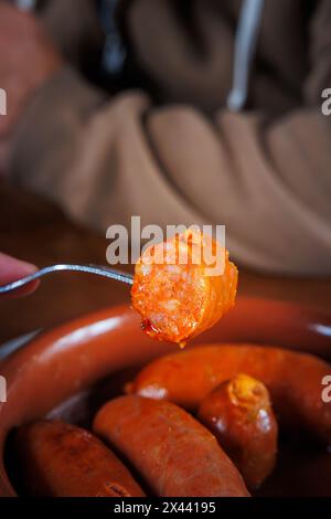 fried chorizo plate tapa cut into pieces ready to eat with a fork Stock ...