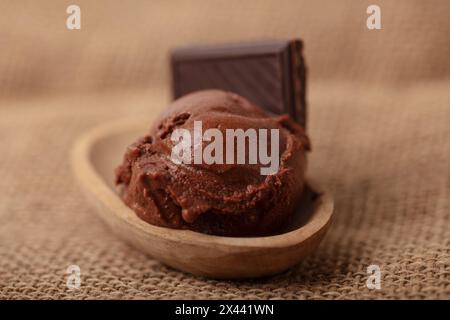 Fresh homemade scoop of chocolate ice cream in a bowl with a piece of chocolate Stock Photo