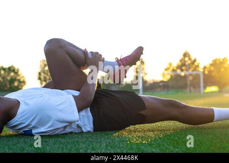 Closeup of a latin soccer player lying on the ground complaining about a soccer injury Stock Photo