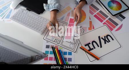 Stylish woman Ux designer using digital tablet and computer planning new website wireframe at creative home office Stock Photo