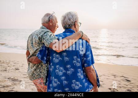 Gay couple with arms around at beach on vacation Stock Photo