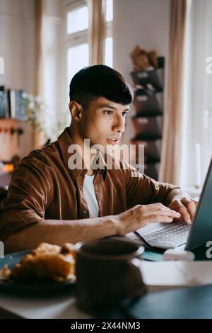 Male freelancer working on laptop at home office Stock Photo