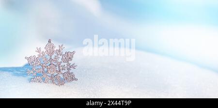 Christmas winter background, banner - view of an decorative snowflake on a snowdrift in a winter forest, copy space for text Stock Photo