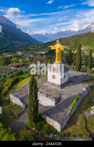 Aerial view of the golden statue of the colossus of Cristo Re. Bienno, Brescia province, Valcamonica valley, Lombardy, Italy, Europe. Stock Photo