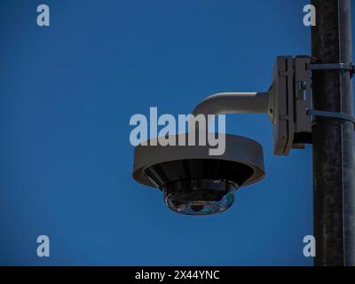 A 360 security camera isolated on blue sky background Stock Photo