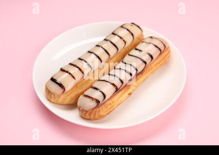Delicious eclairs covered with glaze on pink background Stock Photo