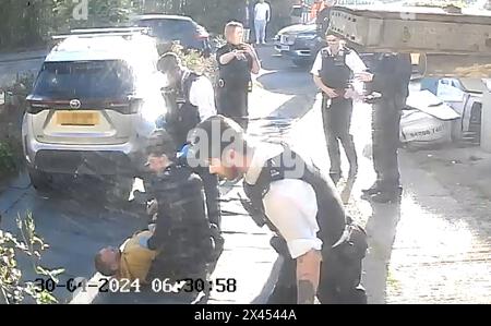 RETRANSMITTED AMENDING BYLINE NUMBERPLATE PIXELATED BY PA PICTURE DESK Handout footage from a doorbell camera of police officers after tasering and detaining a sword-wielding man in Hainault, north east London, after a 14-year-old boy died after being stabbed following an attack on members of the public and two police officers. Picture date: Tuesday April 30, 2024. Stock Photo