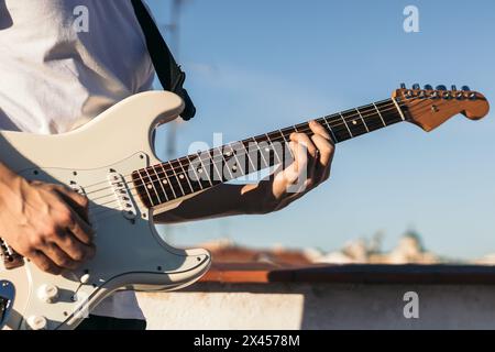 man playing electric guitar on a rooftop Stock Photo