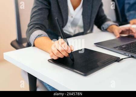 Close-up of an unrecognizable woman using a graphics tablet in an office Stock Photo