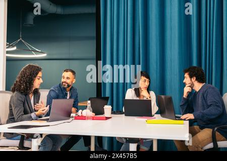 Group of multiracial people working with laptop in a coworkingGroup of people of different races working concentrated and happy with laptops in a cowo Stock Photo