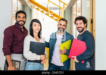 Group portrait of company workers. They look at camera smiling happy to work in a coworking space Stock Photo
