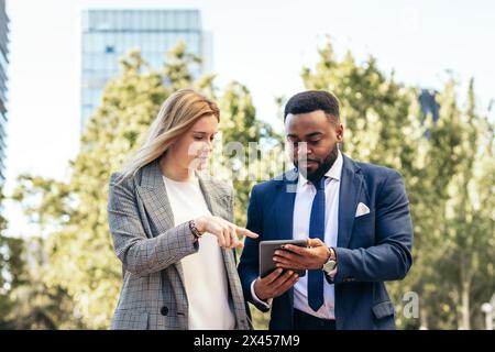 Business people in office clothes using tablet talking about company data outside the office Stock Photo
