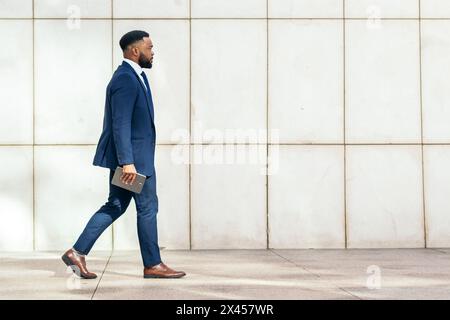 Side view of a black businessman in a suit a on her way to the office Stock Photo