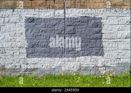 Brick wall painted grey to hide something, UK Stock Photo