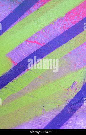Messy paint strokes and smudges on an old painted wall. Pink, purple, yellow color drips, flows, streaks of paint and paint sprays Stock Photo