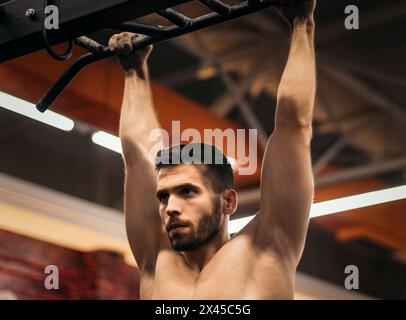 male athlete doing pull ups in a gym Stock Photo