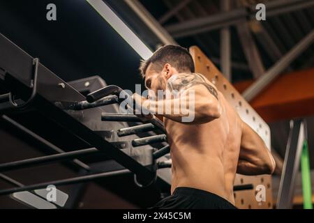male athlete doing muscle ups in a gym Stock Photo