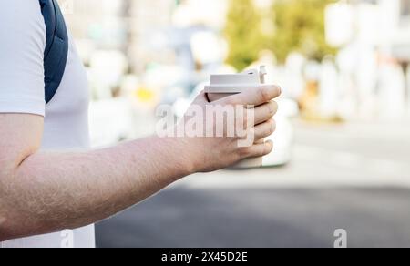 Close-up of the hand of an unrecognizable man holding a takeaway coffee in the city Stock Photo