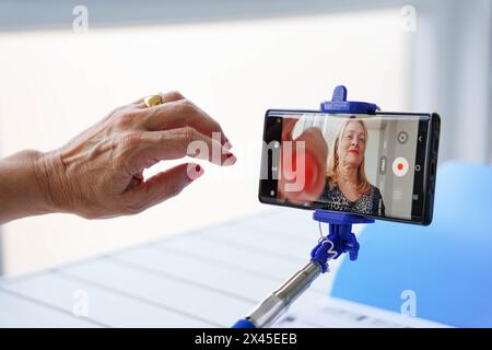 Mature influencer recording a live video on his smartphone. Elderly and social media Stock Photo