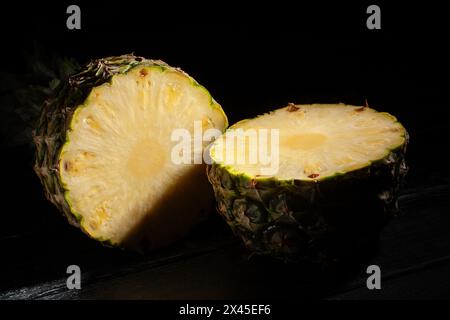 sliced pineapple on black wood background Stock Photo