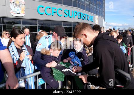 Coventry City's Josh Eccles (right) signs autographs for fans ahead of the Sky Bet Championship match at the Coventry Building Society Arena, Coventry. Picture date: Tuesday April 30, 2024. Stock Photo