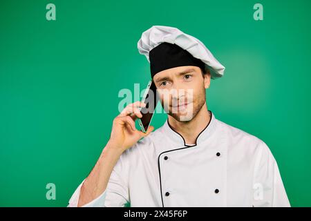 Male chef in white uniform talking on cell phone. Stock Photo