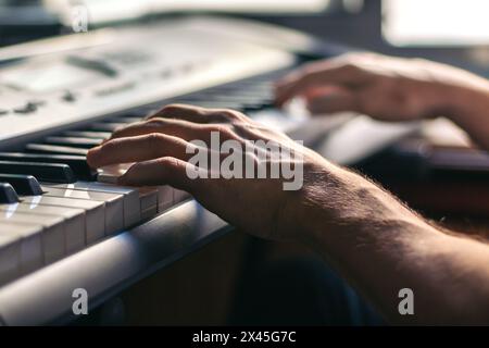 man hands playing the piano close-up. musical keyboard Stock Photo