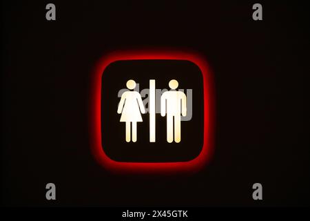Unisex toilet sign on a black wall Stock Photo
