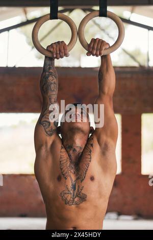 man athlete doing pull ups in gymnastic rings Stock Photo