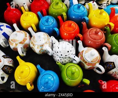Beautiful multicolored oriental-style teapots are on sale at the market. An oriental ceramics street shop. Sale of traditional ceramic tableware durin Stock Photo