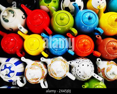 Beautiful multicolored oriental-style teapots are on sale at the market. An oriental ceramics street shop. Sale of traditional ceramic tableware durin Stock Photo