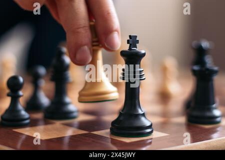 Checkmate. Hand of an unrecognizable man playing chess checkmating his opponent Stock Photo