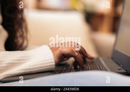 Close-up of a laptop. An unrecognizable person is typing on the keyboard using the computer to work from home Stock Photo