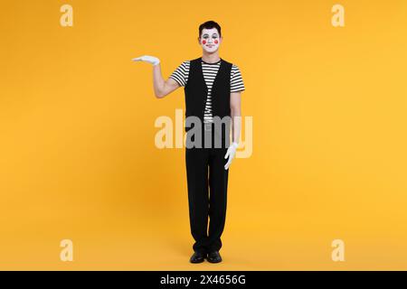 Funny mime artist posing on orange background Stock Photo