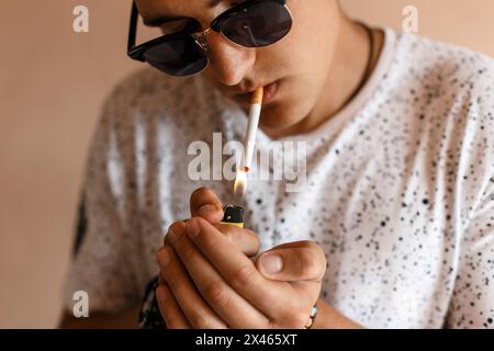 Young Man Lights A Cigarette. Stock Photo