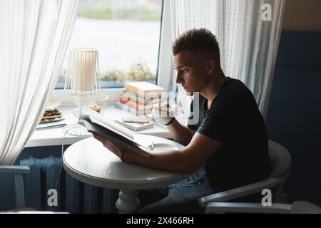 Handsome Man With Coffee Reading A Book. Stock Photo