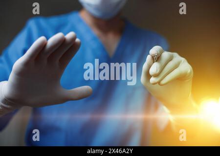 Surgeon Makes Plastic Surgery On The Background Of The Operating Light. Scalpel In Hand. The Concept Of Modern Beauty. Stock Photo