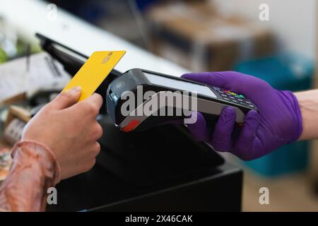 Unrecognizable crop female with plastic card making payment on POS terminal in cafe Stock Photo