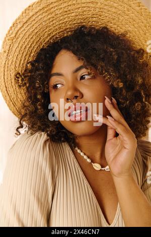 A beautiful young African American woman with curly hair and a summer dress poses for a picture in a studio setting. Stock Photo