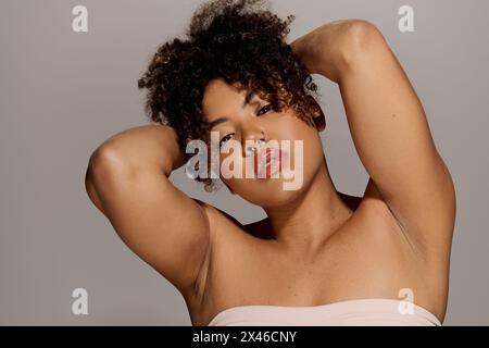 A beautiful young African American woman with curly hair, captured in a mesmerizing close-up shot in a studio setting. Stock Photo
