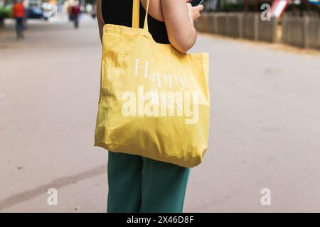 Side view of crop anonymous female with bottle of water walking along crosswalk in city Stock Photo