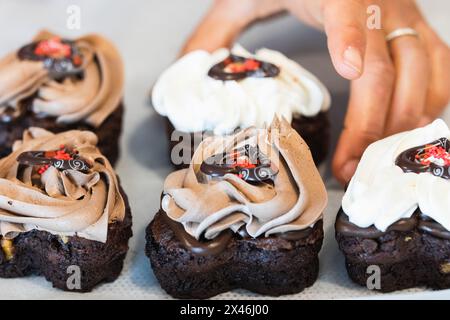 Unrecognizable crop cook holding appetizing vegan sponge cake with chocolate while cooking in kitchen of bakehouse Stock Photo